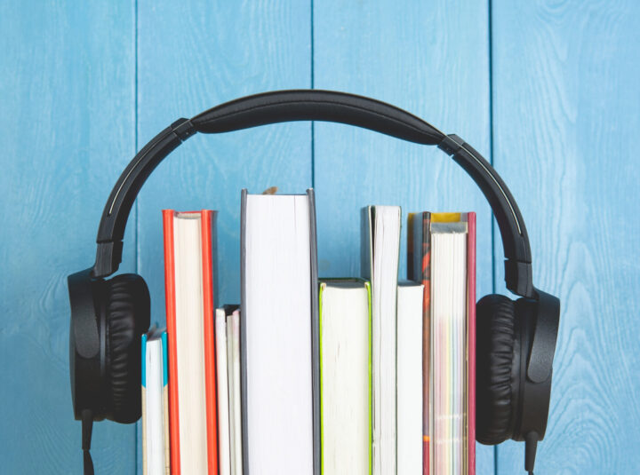 headphone and books on blue background. audio book